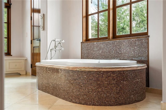 interior space featuring a garden tub, decorative backsplash, and tile patterned floors