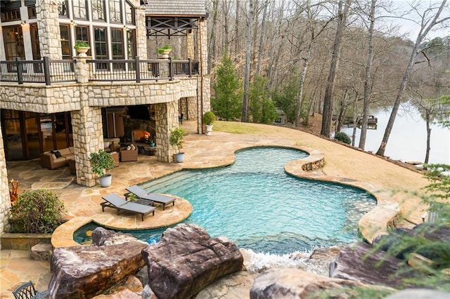 view of pool with an outdoor stone fireplace and a patio area