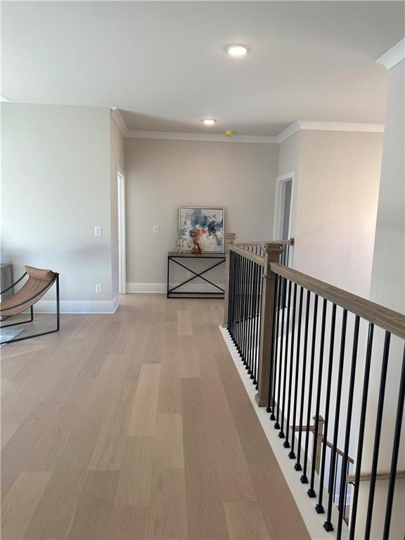 hall with light hardwood / wood-style floors and ornamental molding