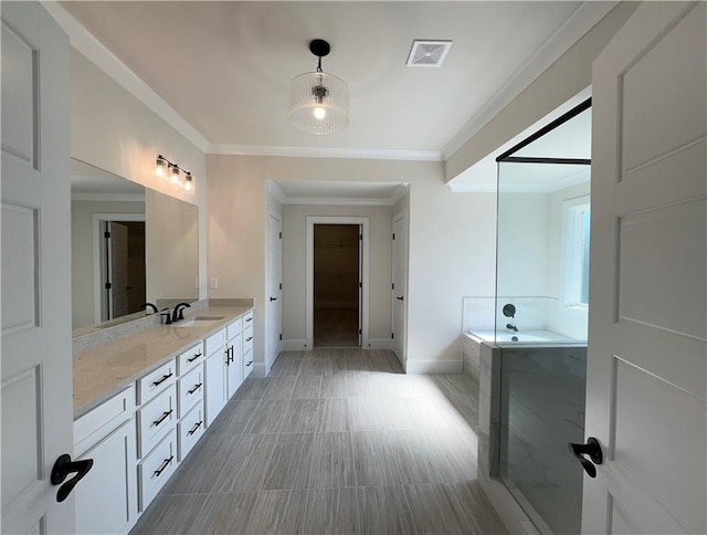 bathroom featuring vanity, crown molding, and tiled tub