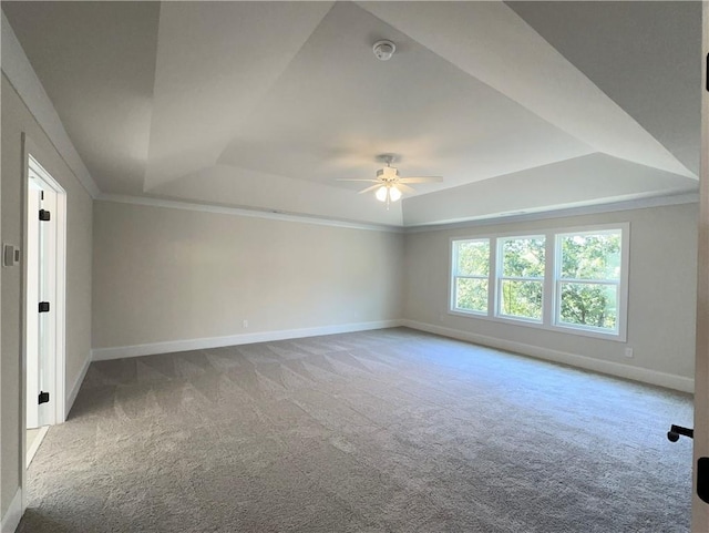 carpeted spare room featuring ceiling fan, ornamental molding, and a tray ceiling