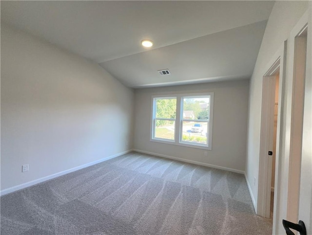 carpeted spare room with lofted ceiling