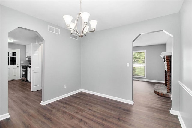 2722 Spring Side Ct, Douglasville, GA 30135 - spare room with dark wood-type flooring, arched walkways, baseboards, a fireplace, and a chandelier