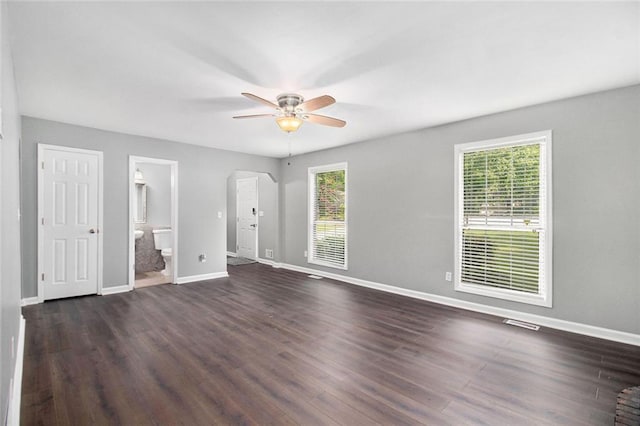 2722 Spring Side Ct, Douglasville, GA 30135 - unfurnished living room with ceiling fan, arched walkways, baseboards, and dark wood-type flooring
