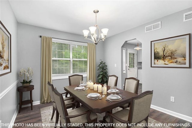 2722 Spring Side Ct, Douglasville, GA 30135 - dining space with arched walkways, dark wood-style flooring, a chandelier, and baseboards
