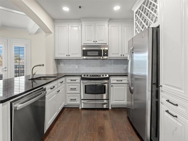 kitchen with stainless steel appliances, kitchen peninsula, sink, and white cabinets