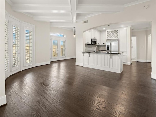 unfurnished living room featuring dark hardwood / wood-style flooring, french doors, and beamed ceiling