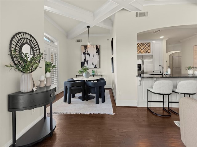 dining room featuring sink, crown molding, dark wood-type flooring, beam ceiling, and coffered ceiling