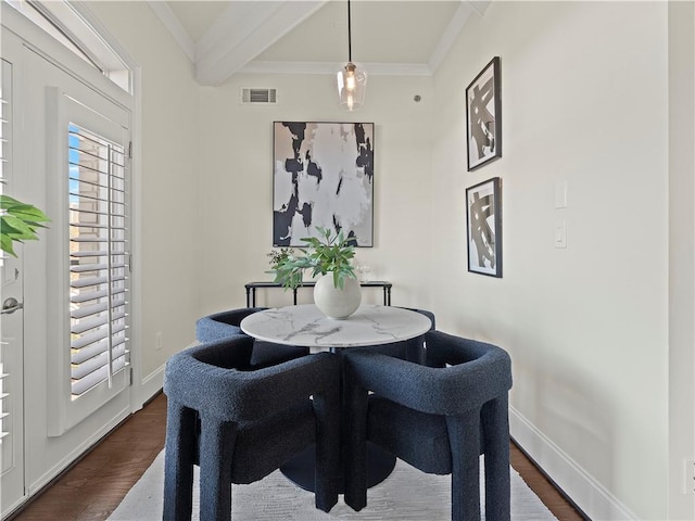 dining space featuring beam ceiling, ornamental molding, and dark hardwood / wood-style flooring