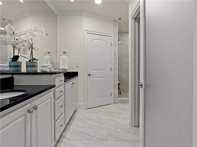 bathroom featuring vanity, ornamental molding, and tiled shower