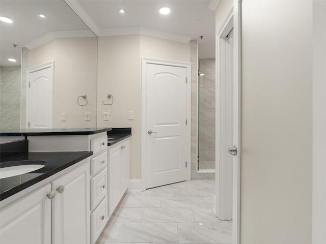 bathroom with crown molding, tiled shower, and vanity