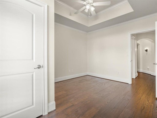 unfurnished room with hardwood / wood-style flooring, crown molding, ceiling fan, and a tray ceiling