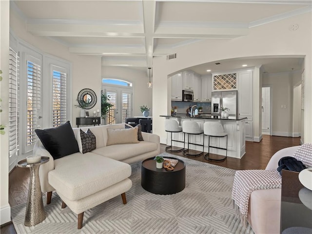 living room featuring crown molding, coffered ceiling, beam ceiling, and dark hardwood / wood-style flooring