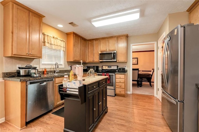 3265 Watson Gate Rd, Loganville, GA 30052 - kitchen with stainless steel appliances, a sink, light wood finished floors, and recessed lighting