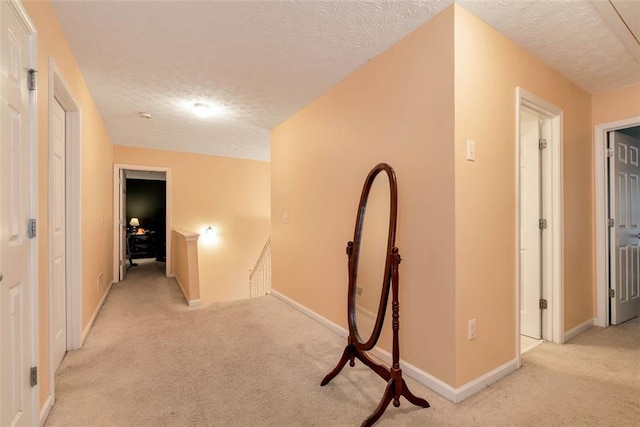 3265 Watson Gate Rd, Loganville, GA 30052 - hallway with light colored carpet, a textured ceiling, an upstairs landing, and baseboards