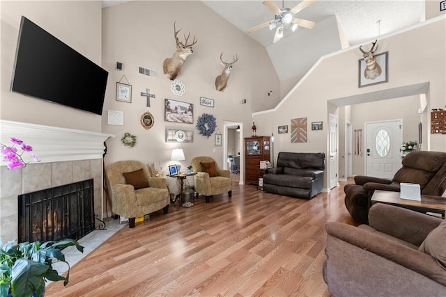 69 Maple Leaf Ct, Hoschton, GA 30548 - living room with ceiling fan, light wood-style flooring, high vaulted ceiling, and a fireplace