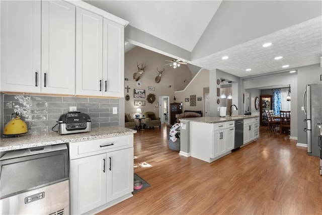 69 Maple Leaf Ct, Hoschton, GA 30548 - kitchen with dishwashing machine, lofted ceiling, backsplash, light stone counters, and white cabinets