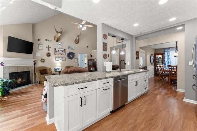 69 Maple Leaf Ct, Hoschton, GA 30548 - kitchen with dishwasher, a textured ceiling, vaulted ceiling, light wood-style flooring, and open floor plan