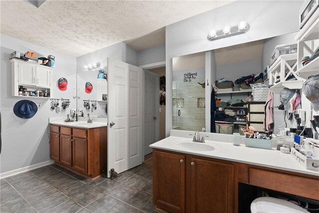 69 Maple Leaf Ct, Hoschton, GA 30548 - bathroom featuring vanity, a stall shower, a textured ceiling, and tile patterned floors