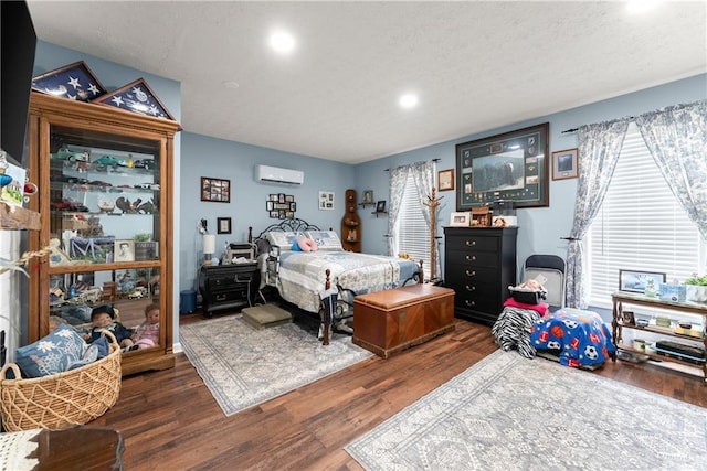 69 Maple Leaf Ct, Hoschton, GA 30548 - bedroom with wood finished floors, a textured ceiling, recessed lighting, and an AC wall unit