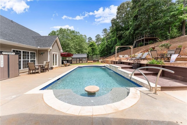 69 Maple Leaf Ct, Hoschton, GA 30548 - view of swimming pool featuring a patio, a shed, outdoor dining space, and view of wooded area