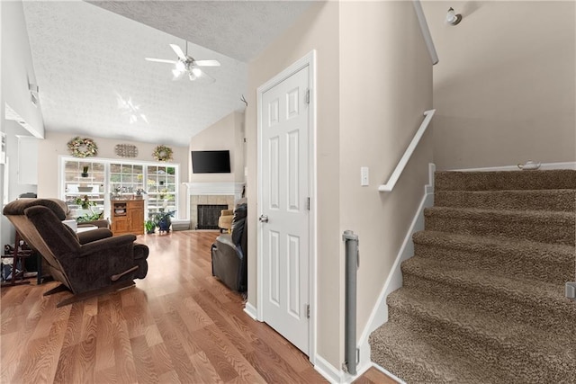 69 Maple Leaf Ct, Hoschton, GA 30548 - living room featuring a ceiling fan, a textured ceiling, stairs, wood finished floors, and a fireplace