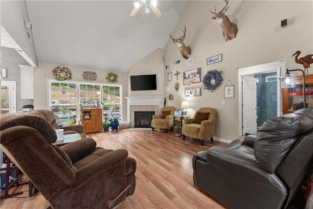 69 Maple Leaf Ct, Hoschton, GA 30548 - living area with high vaulted ceiling, ceiling fan, a fireplace, and light wood-style floors