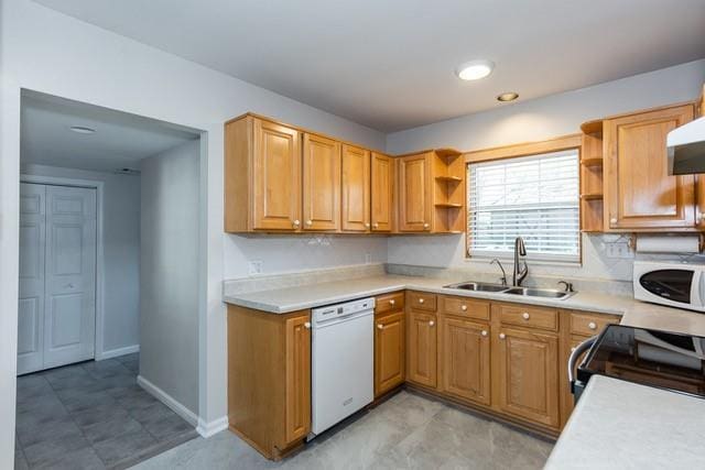 kitchen featuring white appliances, light countertops, open shelves, and a sink