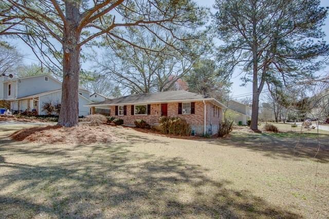 ranch-style house featuring a front yard and brick siding