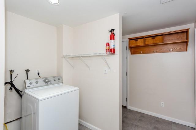 clothes washing area featuring washer / dryer, baseboards, and laundry area