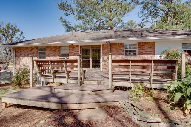 rear view of property with brick siding and a deck