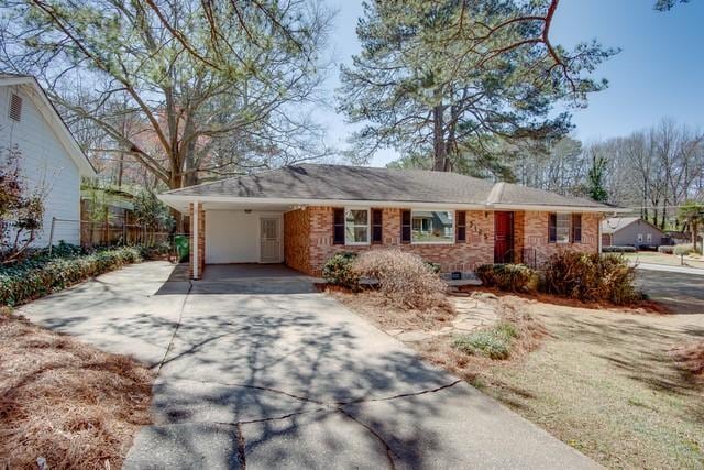 single story home featuring a carport, driveway, and fence