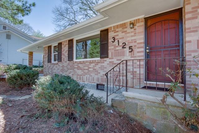 property entrance featuring brick siding