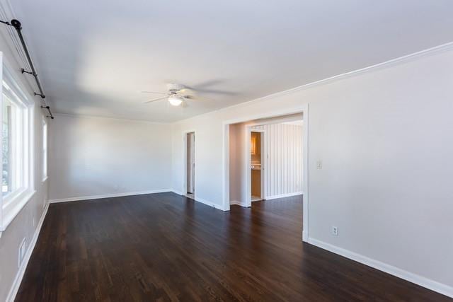 empty room featuring baseboards, dark wood-type flooring, and ceiling fan