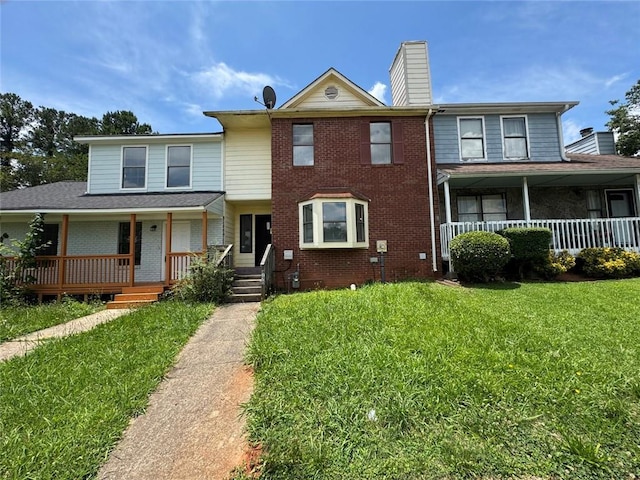 8170 Canyon Forge Dr, Riverdale, GA 30274 - townhome / multi-family property featuring covered porch, brick siding, a chimney, and a front lawn
