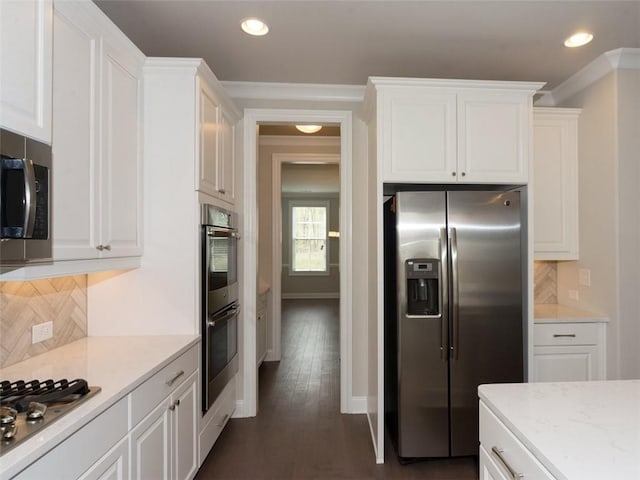 kitchen with white cabinets, stainless steel appliances, decorative backsplash, and recessed lighting