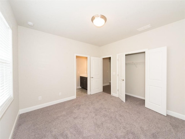 unfurnished bedroom with baseboards, a closet, and light colored carpet