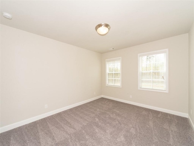 spare room with carpet and baseboards