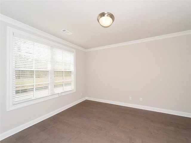 spare room with dark wood-style floors, baseboards, visible vents, and crown molding