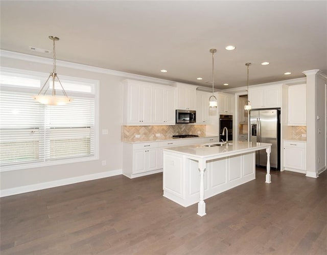 kitchen with white cabinetry, appliances with stainless steel finishes, and decorative light fixtures