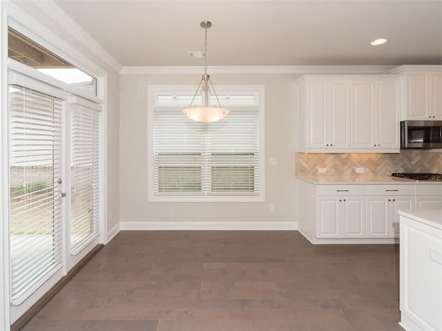 kitchen featuring stainless steel appliances, light countertops, pendant lighting, and white cabinetry