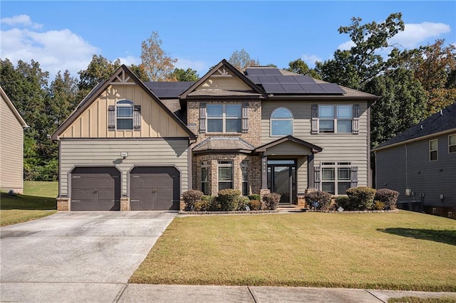 view of front facade with solar panels, a front yard, and a garage