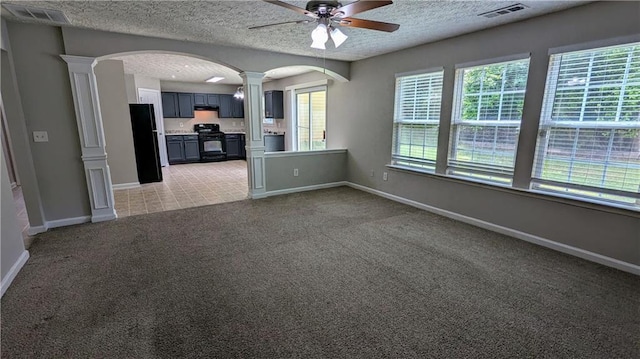 unfurnished room featuring ornate columns, ceiling fan, arched walkways, baseboards, and light carpet