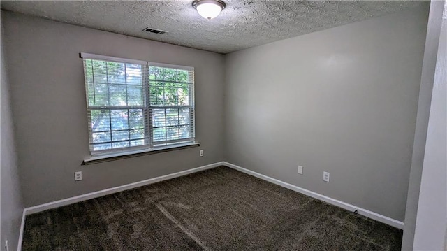 unfurnished room with dark carpet, baseboards, and a textured ceiling