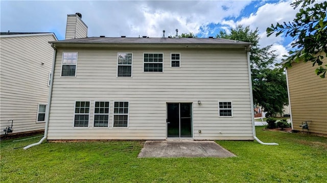 rear view of house with a patio area, a lawn, and a chimney