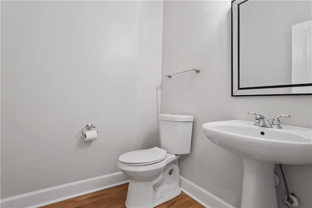 bathroom featuring wood-type flooring, toilet, and sink