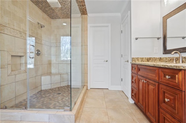 bathroom featuring an enclosed shower, vanity, crown molding, and tile patterned floors