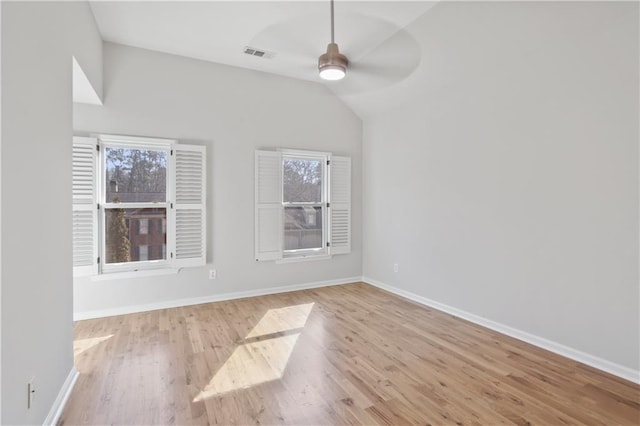 spare room featuring ceiling fan, lofted ceiling, and light wood-type flooring