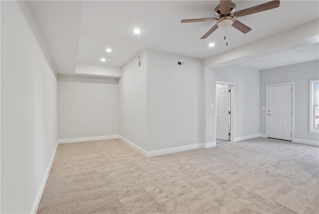 spare room featuring light colored carpet and ceiling fan