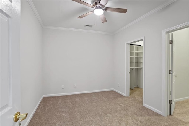 unfurnished bedroom featuring light colored carpet, ornamental molding, a spacious closet, and a closet